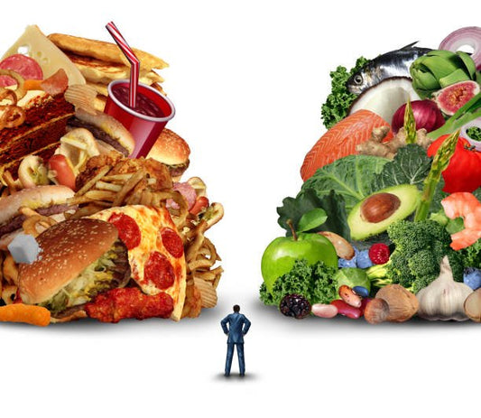 Man comparing unhealthy fast food with healthy fruits and vegetables, illustrating dietary choices.