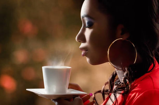 Woman enjoying a cup of tea with steam rising, highlighting the relaxing moment.