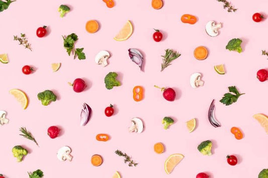 Färgglada grönsaker och frukter på rosa bakgrund, exemplifierar hälsosam kost och hälsokostprodukter.