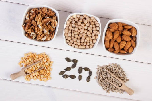 Skålar med nötter och frön, inklusive valnötter, mandlar och pumpafrön, rik på zink och protein.