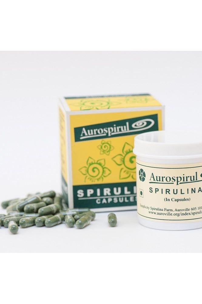 Aurospirul Spirulina capsules with packaging and spilled capsules, a nutrient-rich dietary supplement.