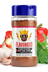 FlavorGod Everything But The Salt Seasoning bottle with fresh vegetables, garlic, and herbs.