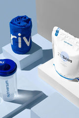 Nutriversum BCAA supplement package with shaker cup and towel on blue background.