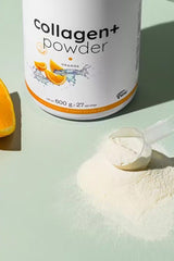 Nutriversum Collagen+ Powder in orange flavor next to a scoop and orange slices on a green surface.