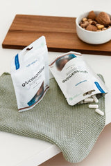 Nutriversum Glucosamine Sulphate capsules packaging on a kitchen counter with almonds.