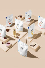 Variety of Nutriversum Iso Pro protein powder bags with flavors displayed creatively.