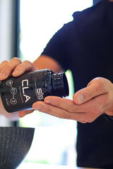 Person pouring Science in Sport CLA capsules into a bowl for improved body composition and fat loss.