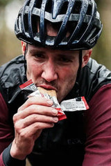Athlete wearing a helmet enjoying a Science in Sport Go Energy Bake during training.