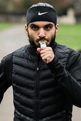 Athlete consuming Science in Sport isotonic energy gel during outdoor training session.