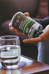 Science in Sport Performance Multivitamin Gummies container with gummies being poured next to a glass of water.