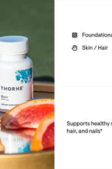 Thorne Biotin dietary supplement bottle with grapefruit slices, promoting healthy skin, hair, and nails.