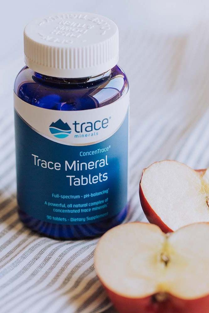 Trace Minerals ConcenTrace Trace Mineral Tablets bottle with sliced apple, dietary supplement for energy and nutrition. Trace Minerals ConcenTrace Trace Mineral Tablets bottle with sliced apple, dietary supplement for energy and nutrition.