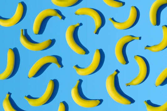 Mönstrat bild av gula bananer på blå bakgrund, symboliserar hälsosamma snacks och matval.