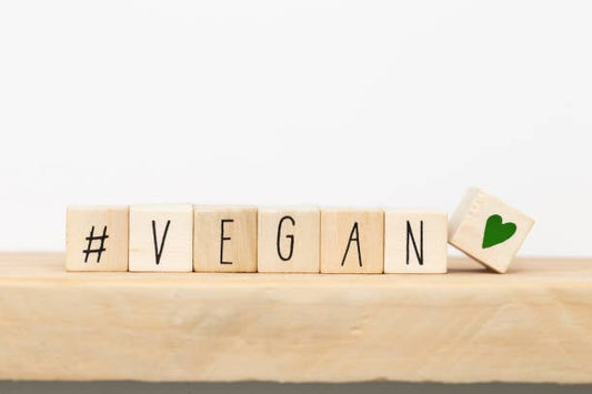 Wooden blocks spelling #VEGAN with a heart symbol, representing vegan lifestyle and community.