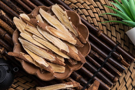 Torkad astragalusrot i en skål, som används i traditionell kinesisk medicin för sina hälsofördelar.