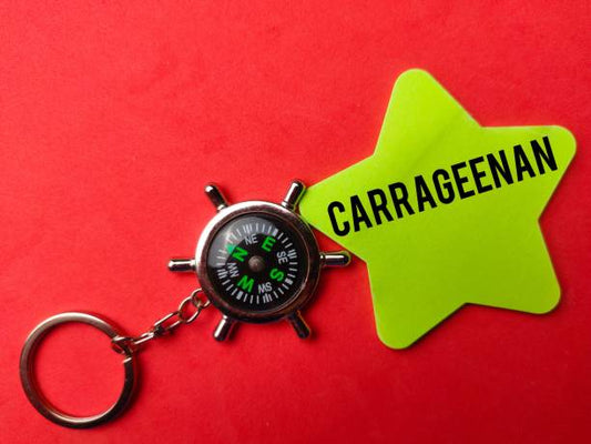A compass keychain next to a bright star-shaped tag labeled "CARRAGEENAN" on a red background.