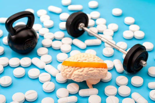 Brain model with a headband, dumbbell, and pills on a blue background representing nootropics for cognitive enhancement.