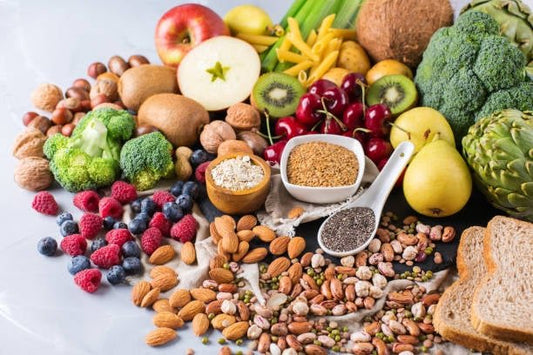 A colorful assortment of vegan protein sources including fruits, vegetables, nuts, seeds, and whole grains.