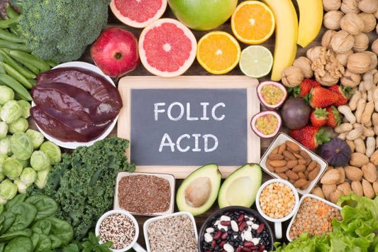 Colorful assortment of fruits, vegetables, and nuts with chalkboard labeled 'Folic Acid' promoting healthy eating.
