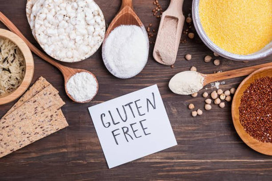 Variety of gluten-free grains and products arranged with a sign that says 'Gluten Free' on a wooden background.