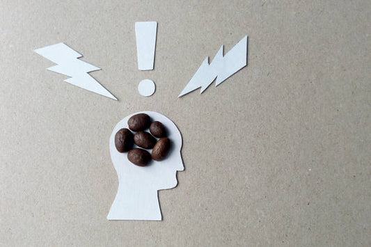 Silhouette of a head with coffee beans and lightning bolts, representing caffeine sensitivity.
