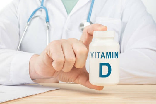 Läkare som håller en flaska D-vitamin i handen, vikt för immunförsvar och kalciumabsorption.