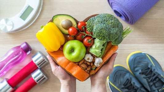Färsta grönsaker och frukter i hjärtformad skål som främjar hälsosam kost och kolesterolkontroll.