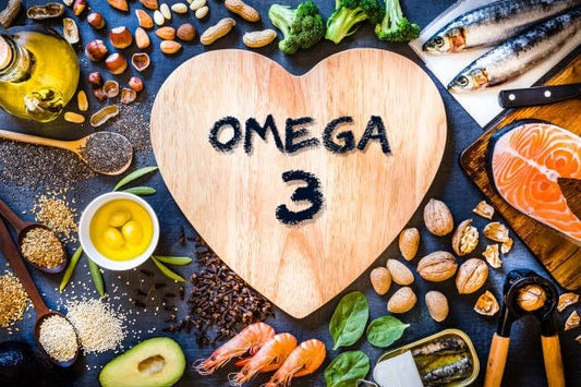 Heart-shaped wooden board with 'Omega 3' surrounded by healthy food items rich in Omega 3.