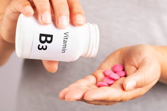 Person pouring Vitamin B3 pills into hand, highlighting niacinamid's health benefits.