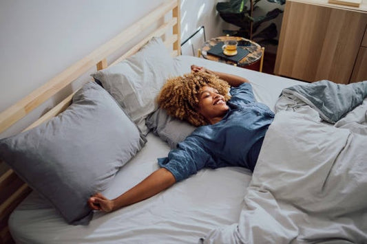Woman relaxing in bed with pillows, promoting restful sleep and natural remedies for insomnia.