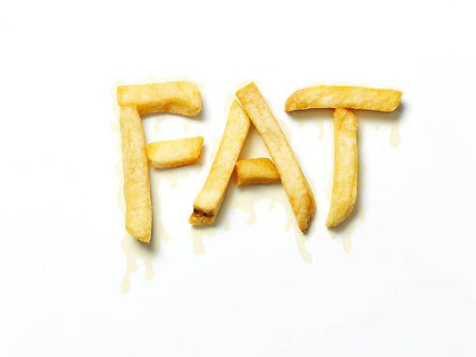 Pommes frites formade till texten "FAT" på vit bakgrund, symboliserande kostfett.