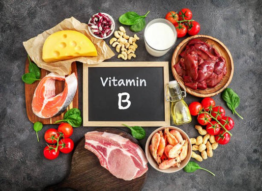 Image of various foods rich in Vitamin B including meats, cheese, and nuts on a dark background.