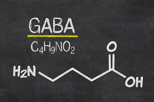 Strukturformel för GABA, en neurotransmittor och aminosyra, illustrerad på en svart tavla.