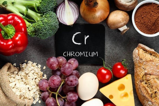 Colorful arrangement of foods rich in chromium with a chalkboard showing 'Cr' and 'Chromium'.
