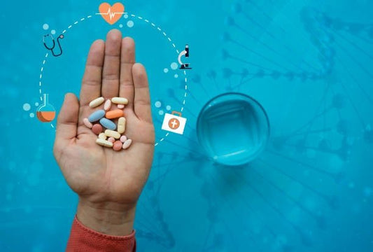 Hand holding various colorful pills over a blue background with health-related icons.