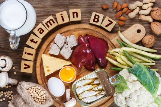 Hälsosamma livsmedel rikt på vitamin B7, inklusive ägg, lever, nötter och grönsaker, med text "vitamin B7".