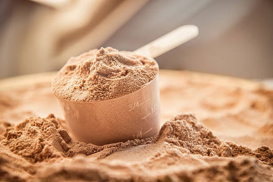 En skopa med whey proteinpulver på en yta av proteinpulver.