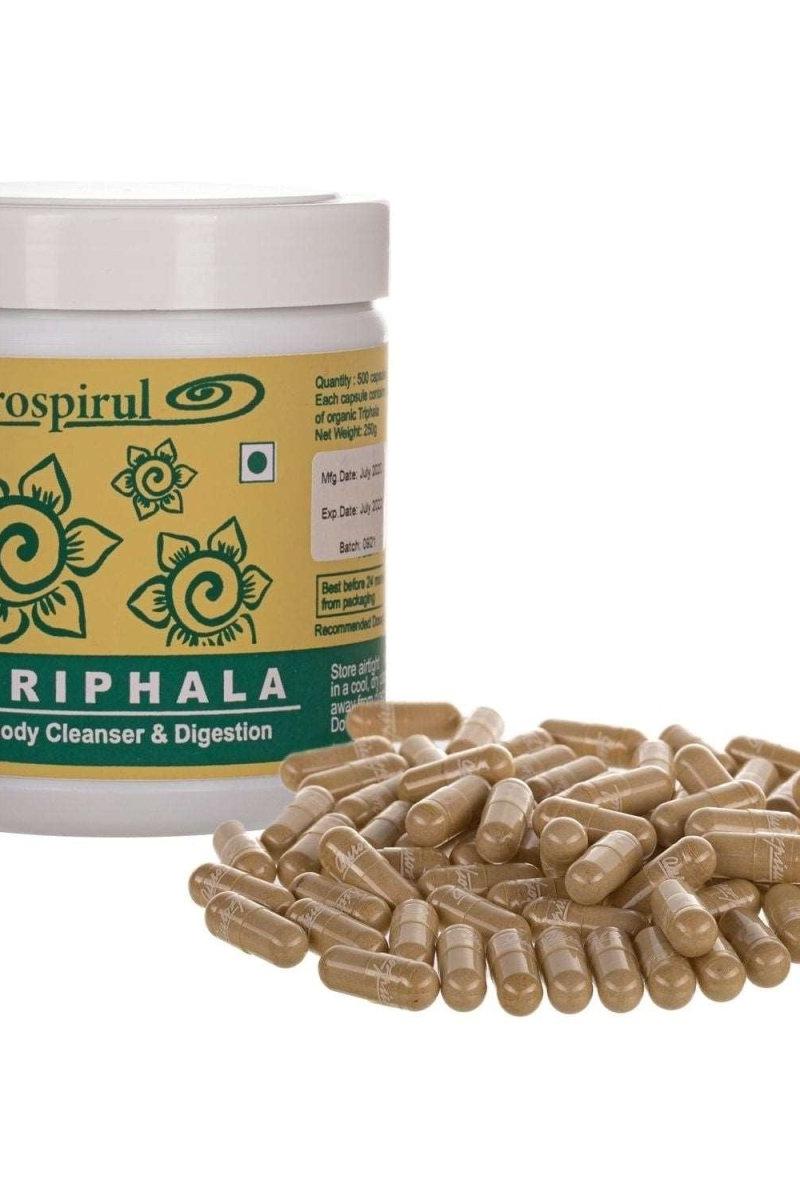 Aurospirul Triphala supplement powder with capsules in front, supporting digestion and body cleansing.