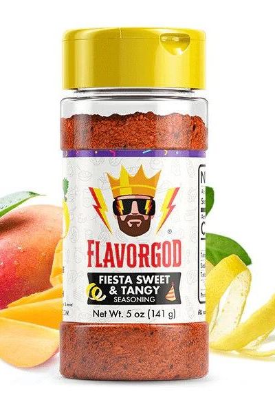 FlavorGod Fiesta Sweet & Tangy Seasoning bottle with mango and lemon slices, perfect for enhancing flavors.