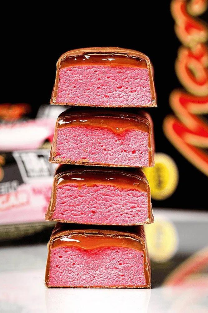 Stack of Mars Raspberry Smash Protein Bars with pink raspberry filling and chocolate coating.