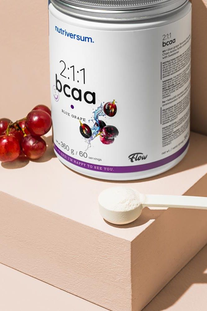 Nutriversum 2:1:1 BCAA powder in grape flavor with scoop, 360g container, on a pastel background.
