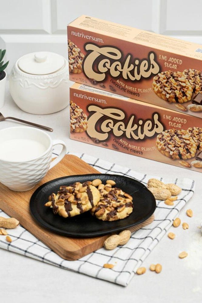 Nutriversum cookies with no added sugar on a plate, alongside a cup of milk and packaging.