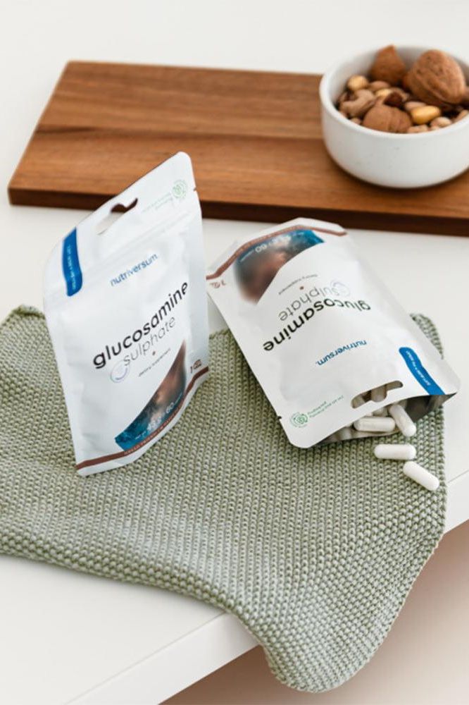 Nutriversum Glucosamine Sulphate capsules packaging on a kitchen counter with almonds.