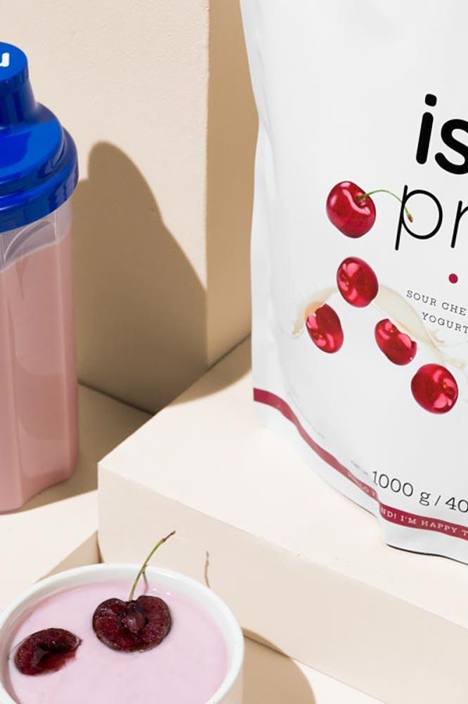 Nutriversum Iso Pro protein powder bag with a shaker and yogurt topped with cherries.