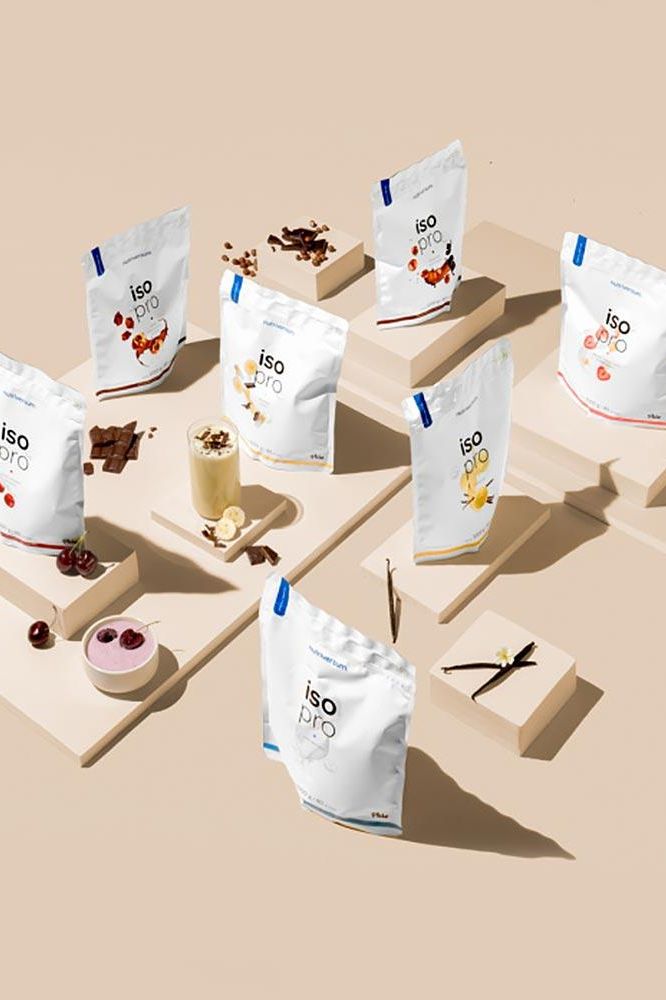 Variety of Nutriversum Iso Pro protein powder bags with flavors displayed creatively.