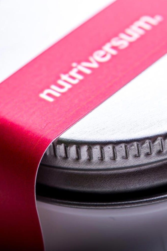 Close-up of Nutriversum container lid featuring a red label with logo.