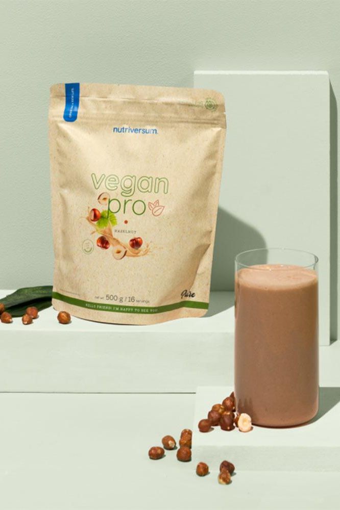 Nutriversum Vegan Pro protein powder packaging with a glass of smoothie and nuts on a pastel background.