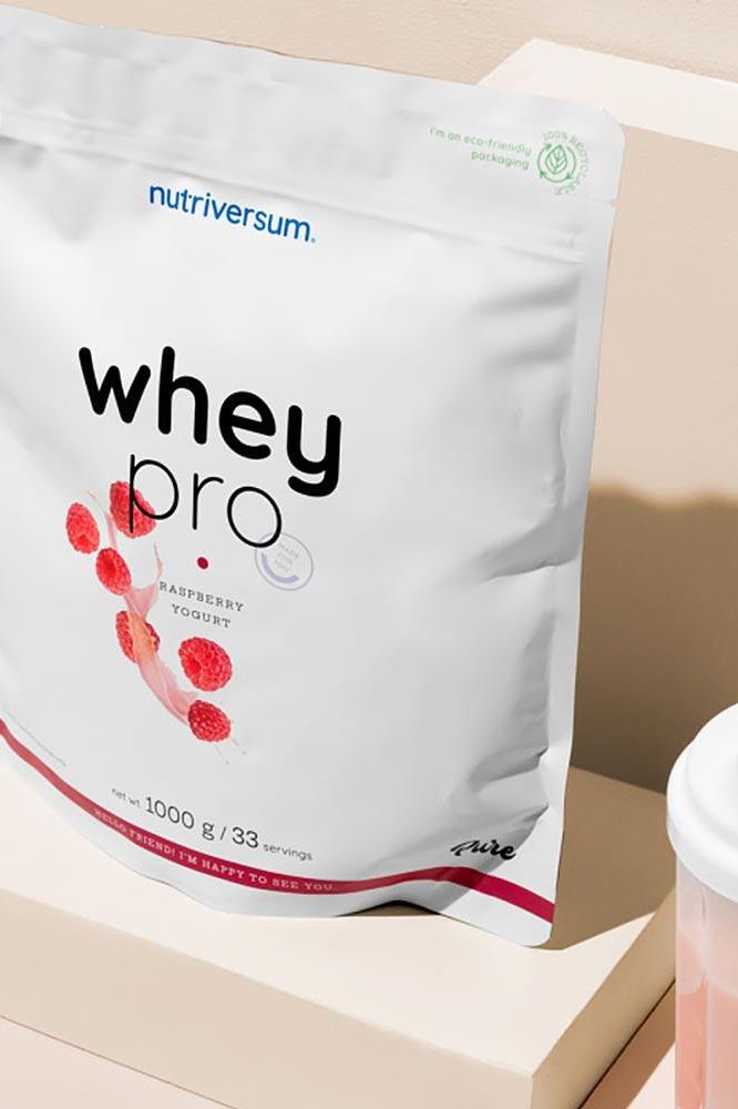 Nutriversum Whey PRO - PURE protein powder packaging with raspberry yogurt flavor, offering 23g protein per serving.