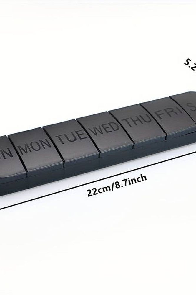 Oly Maxi Pill Box showing seven compartments for daily medication, measuring 22cm x 5.2cm in sleek black design.