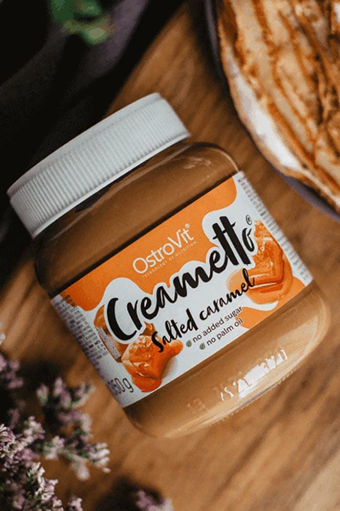 OstroVit Creametto salted caramel jar on a wooden surface, featuring a healthy spread option.